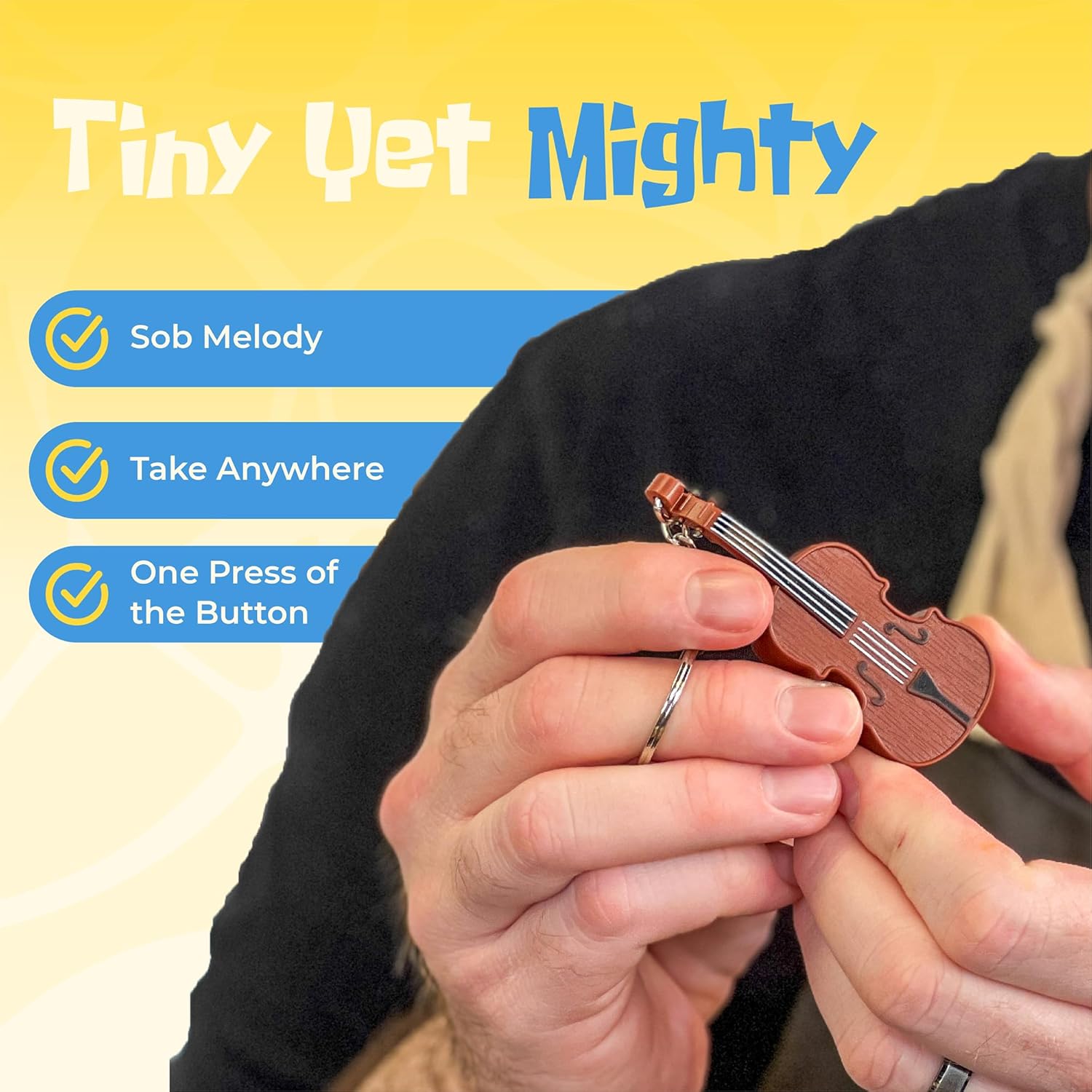 A tiny wooden violin keychain held in someone's hand against a yellow background, featuring a checkmarked list highlighting its "Sob Melody," portability, and one-button operation.