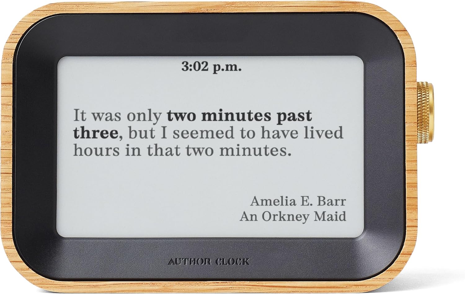A wooden-framed Author Clock with a black bezel displays a literary quote by Amelia E. Barr from "An Orkney Maid" at 3:02 p.m., featuring an e-ink display that shows a different book passage for each minute of the day.