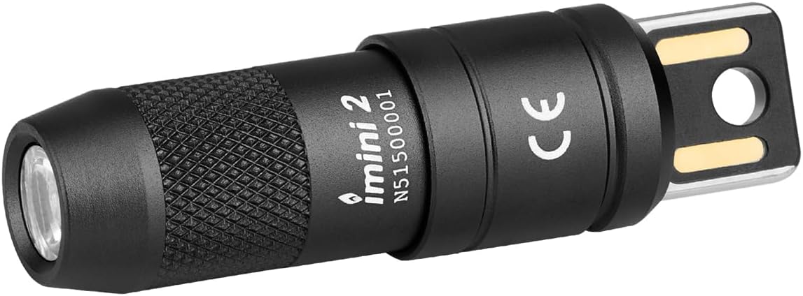 Compact black cylindrical USB rechargeable flashlight with textured grip, featuring a magnetic base with brass contact points on the rear end.
