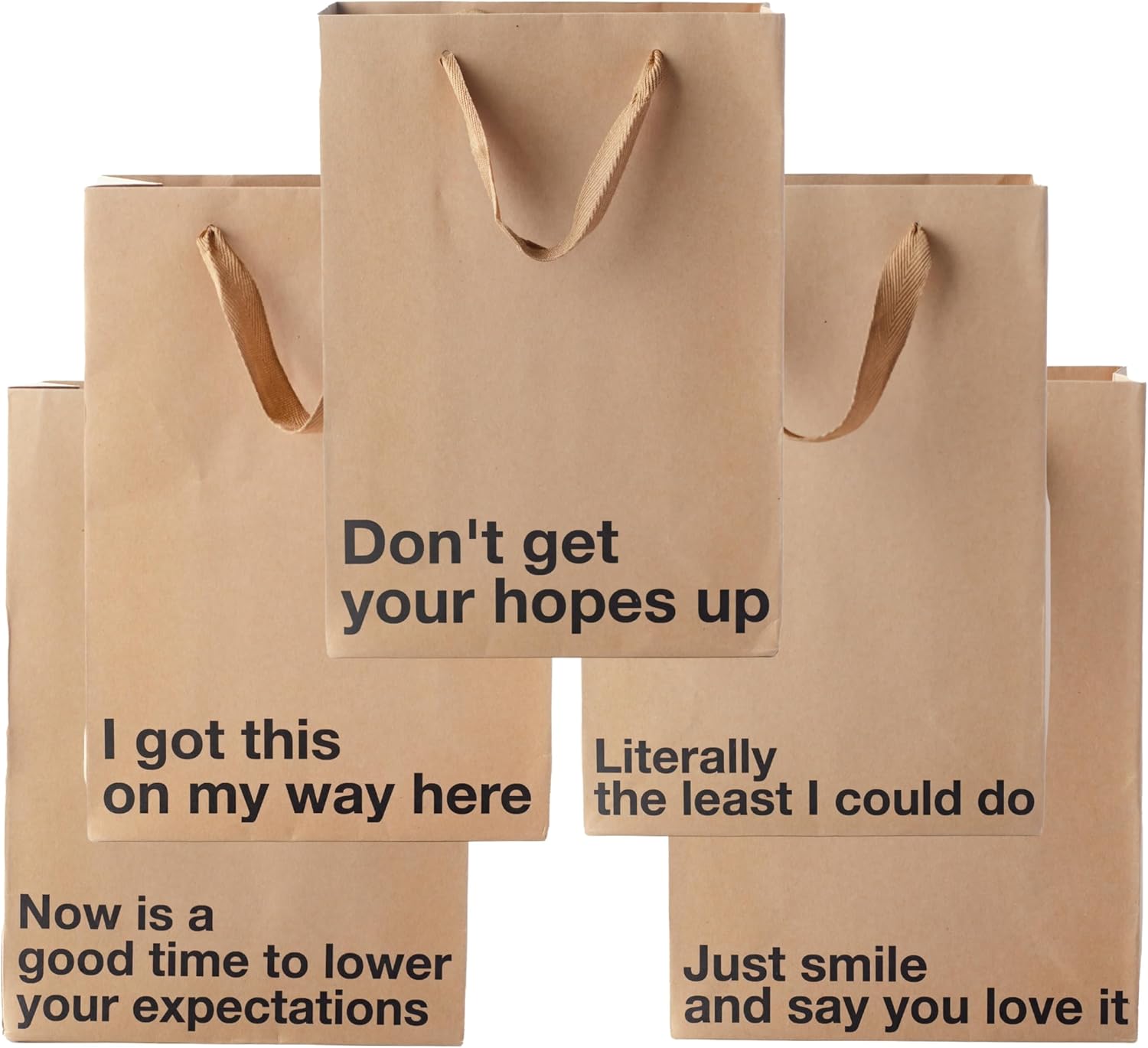 A set of kraft paper gift bags with rope handles arranged in a cross pattern, each displaying humorous text including "Don't get your hopes up," "I got this on my way here," "Literally the least I could do," "Now is a good time to lower your expectations," and "Just smile and say you love it."
